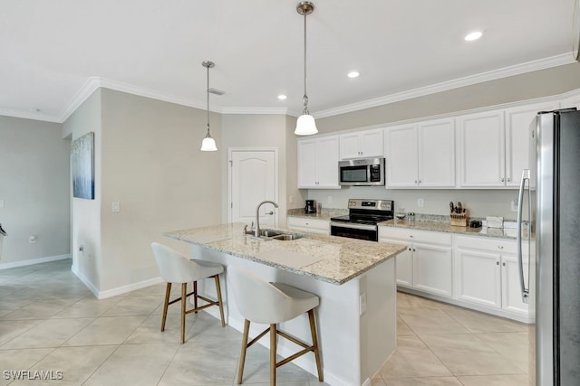 kitchen featuring white cabinets, decorative light fixtures, stainless steel appliances, and a kitchen island with sink