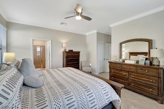 bedroom featuring ensuite bath, ceiling fan, and crown molding