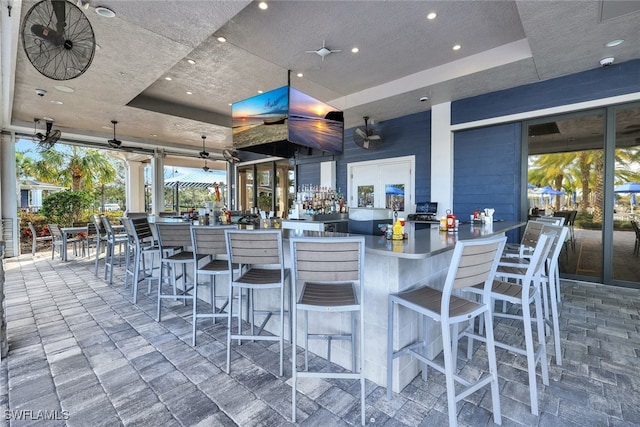 view of patio with a bar and ceiling fan