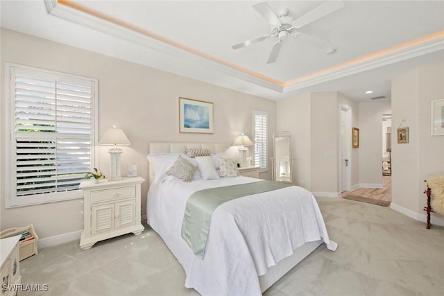 carpeted bedroom featuring ceiling fan, crown molding, and a tray ceiling