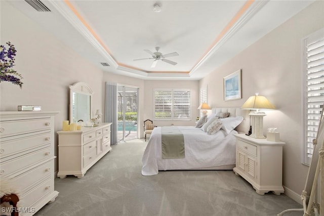 carpeted bedroom featuring ceiling fan, ornamental molding, access to outside, and a tray ceiling