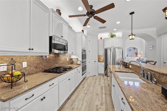 kitchen featuring decorative light fixtures, white cabinetry, sink, and appliances with stainless steel finishes