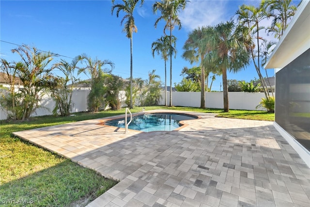 view of pool with a patio area and a yard