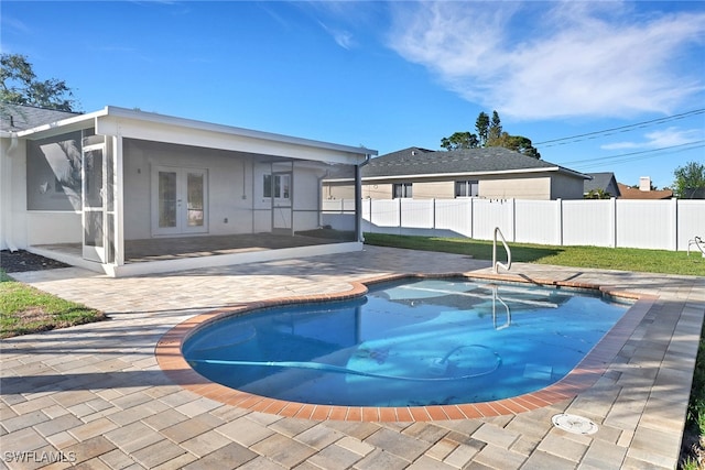 view of swimming pool featuring french doors, a patio, and a sunroom