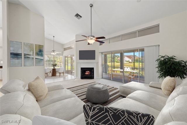 carpeted living room featuring a wealth of natural light, ceiling fan, and high vaulted ceiling