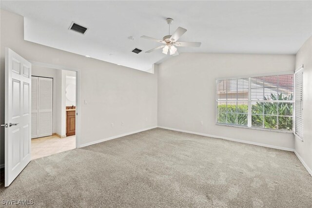 spare room featuring light carpet, ceiling fan, and lofted ceiling