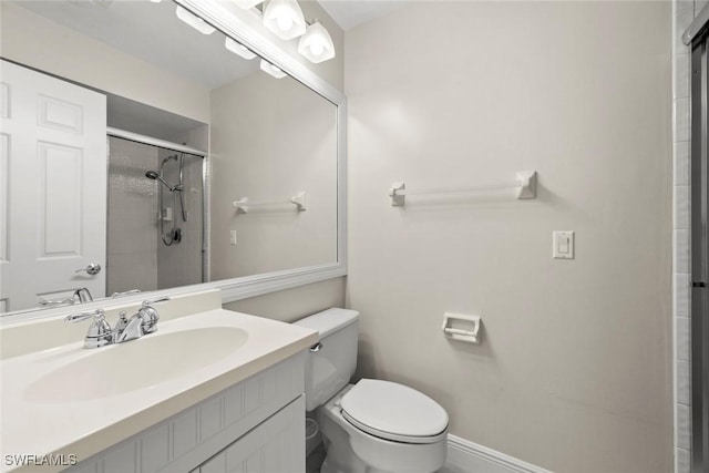 full bathroom with toilet, baseboards, an enclosed shower, and vanity