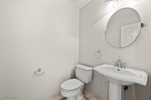 bathroom featuring toilet and baseboards