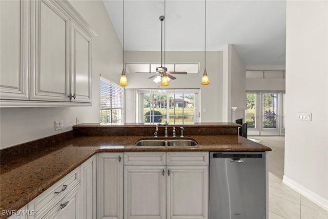 kitchen featuring ceiling fan, sink, stainless steel dishwasher, dark stone counters, and white cabinets