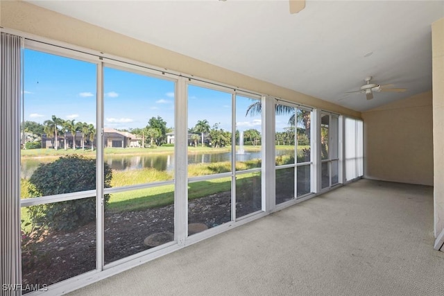 unfurnished sunroom featuring a water view and ceiling fan