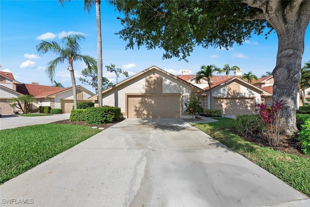 view of front of house with a garage, driveway, a front lawn, and stucco siding