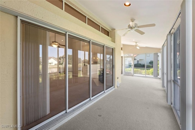 unfurnished sunroom featuring vaulted ceiling and a ceiling fan