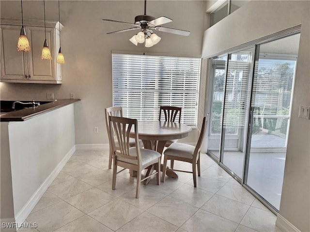 tiled dining area with ceiling fan, sink, and a wealth of natural light