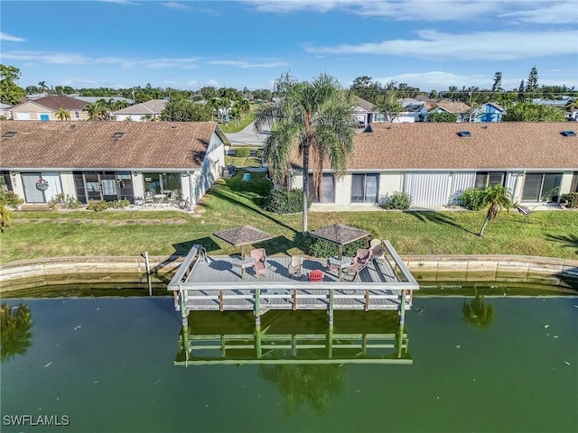 view of dock with a yard and a water view