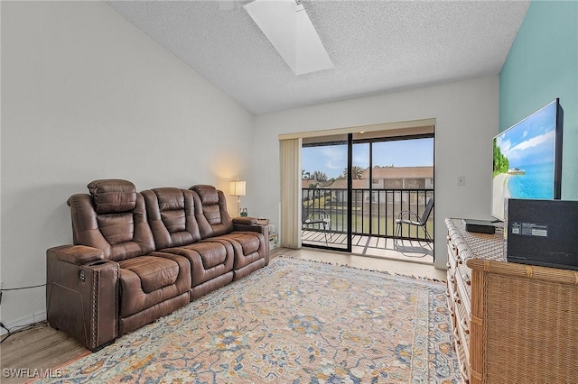 living room with a skylight, hardwood / wood-style floors, and a textured ceiling