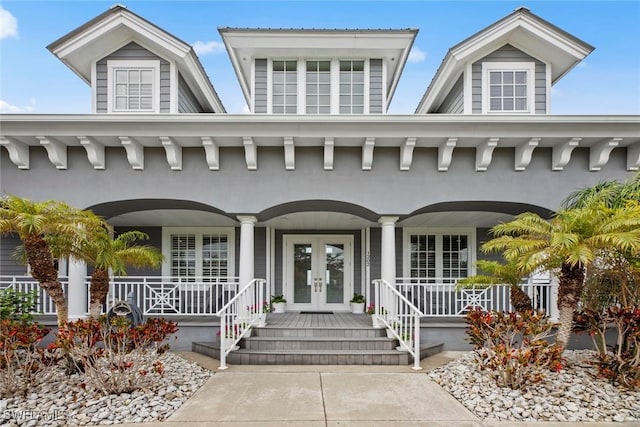 view of exterior entry with french doors and a porch