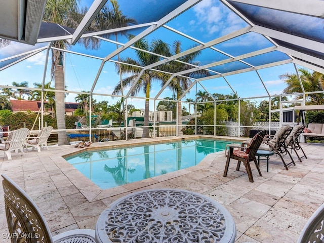 view of swimming pool featuring glass enclosure and a patio area