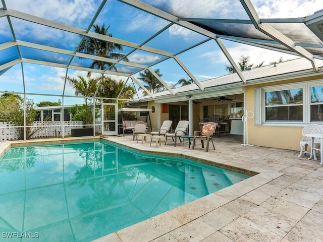view of pool featuring a patio, ceiling fan, and a lanai