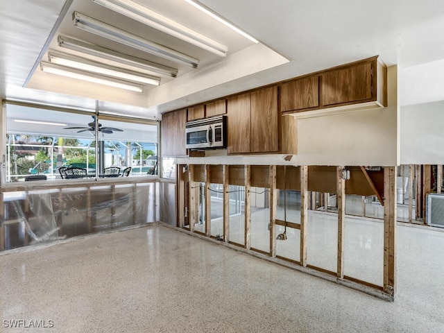 kitchen with ceiling fan and a raised ceiling