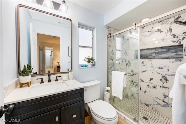 bathroom featuring vanity, toilet, and a shower with shower door