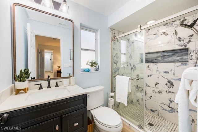 bathroom with vanity, an enclosed shower, and toilet