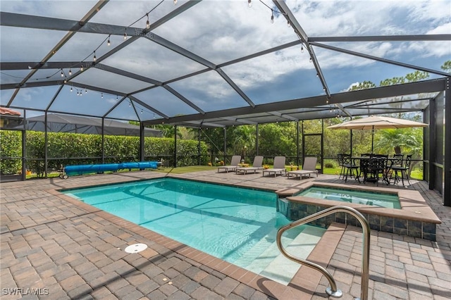 view of swimming pool with glass enclosure, a patio area, and an in ground hot tub