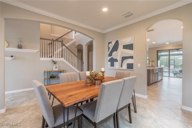 dining space with light tile patterned floors and crown molding