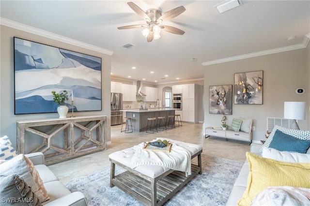 living room featuring crown molding, sink, and ceiling fan