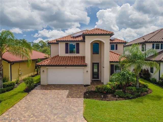 mediterranean / spanish home featuring a front yard and a garage