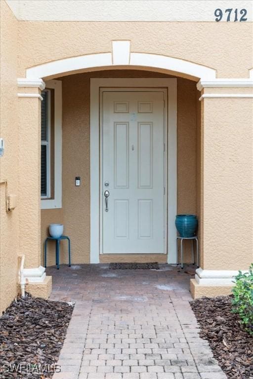 property entrance featuring stucco siding