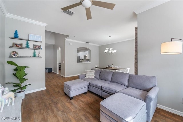 living room with ornamental molding, dark hardwood / wood-style floors, and ceiling fan with notable chandelier