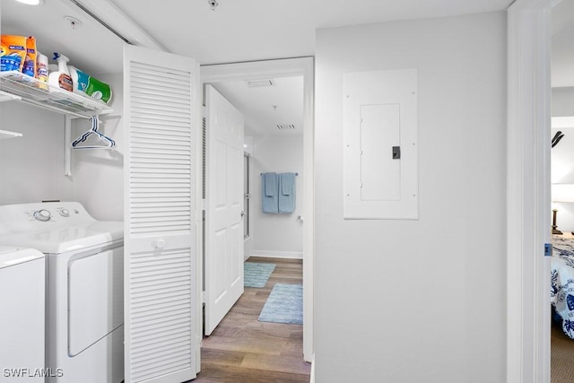 clothes washing area featuring independent washer and dryer, electric panel, and hardwood / wood-style floors