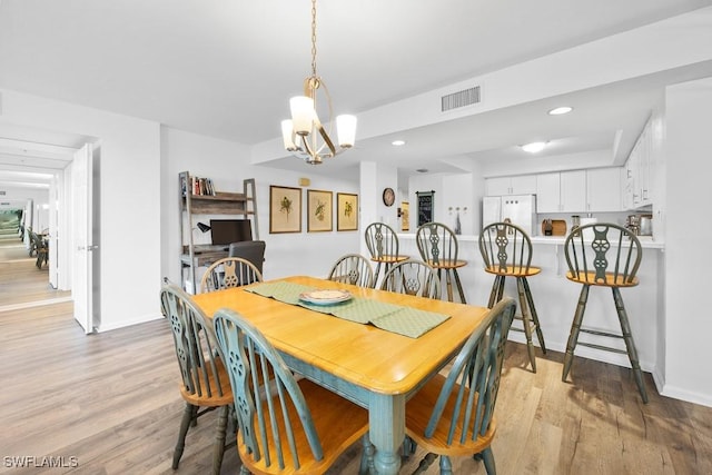 dining area with a chandelier and light wood-type flooring