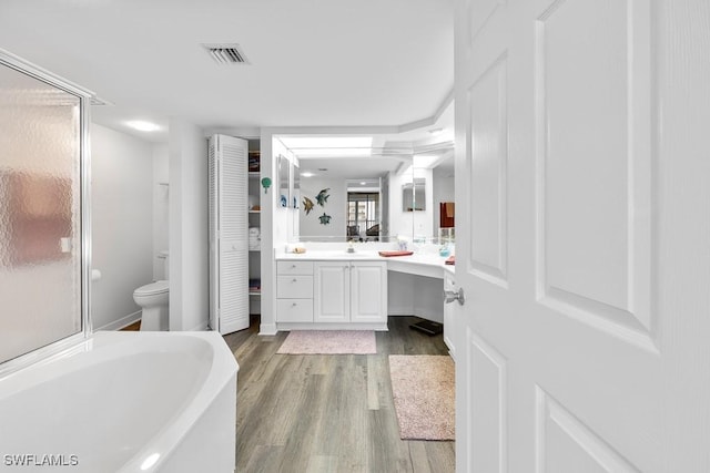 full bathroom featuring independent shower and bath, vanity, wood-type flooring, and toilet