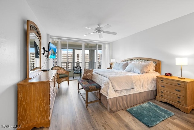 bedroom featuring access to exterior, light hardwood / wood-style floors, ceiling fan, and floor to ceiling windows