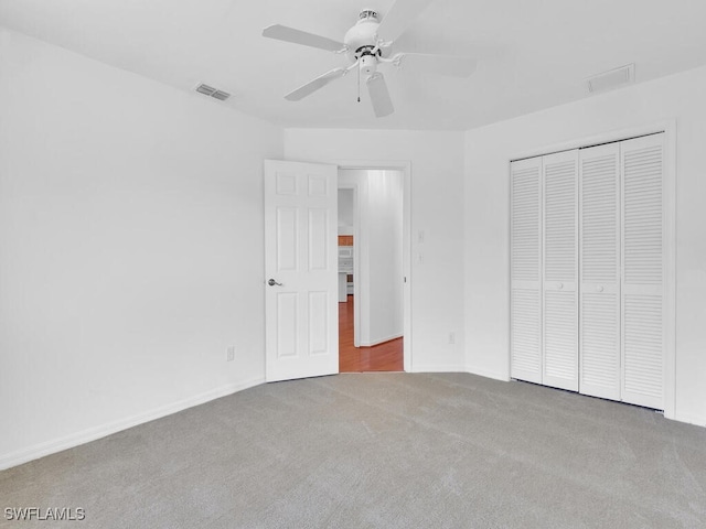 unfurnished bedroom with carpet flooring, ceiling fan, and a closet