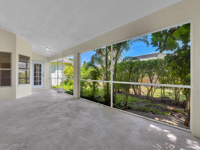 unfurnished sunroom featuring vaulted ceiling