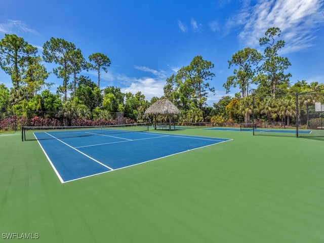 view of tennis court featuring basketball hoop