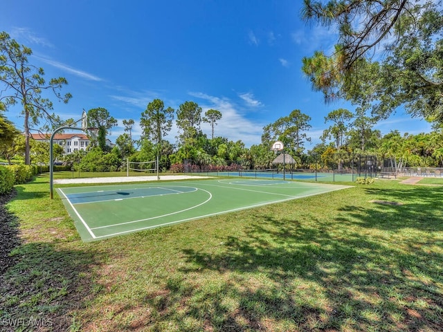 view of sport court featuring a lawn and tennis court