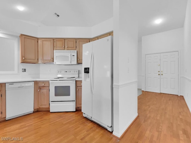 kitchen featuring light brown cabinetry, light hardwood / wood-style floors, and white appliances