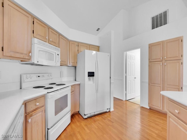 kitchen with light brown cabinets, white appliances, light hardwood / wood-style floors, and lofted ceiling