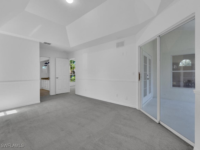 carpeted empty room featuring a raised ceiling and ceiling fan