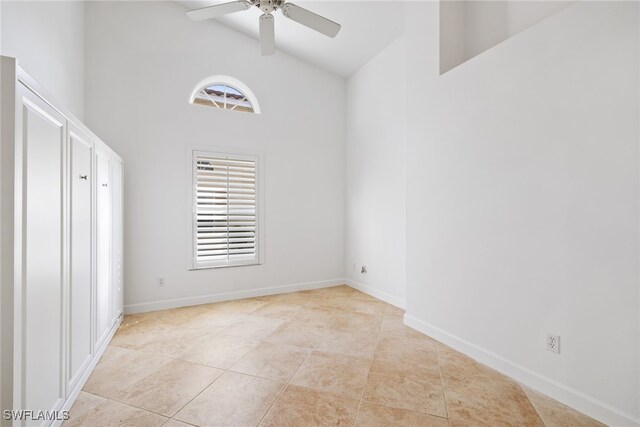 8526 Mustang Dr, Naples, FL 34113 - unfurnished bedroom with baseboards, high vaulted ceiling, a ceiling fan, and light tile patterned floors