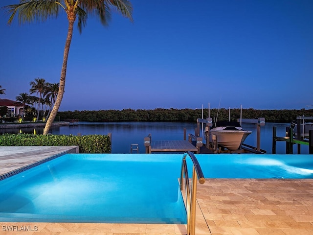 pool at dusk with a dock and a water view