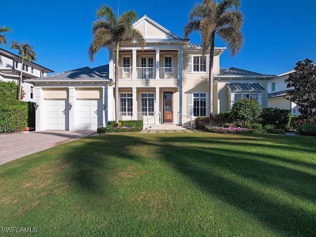 greek revival inspired property with a front yard, a balcony, and a garage