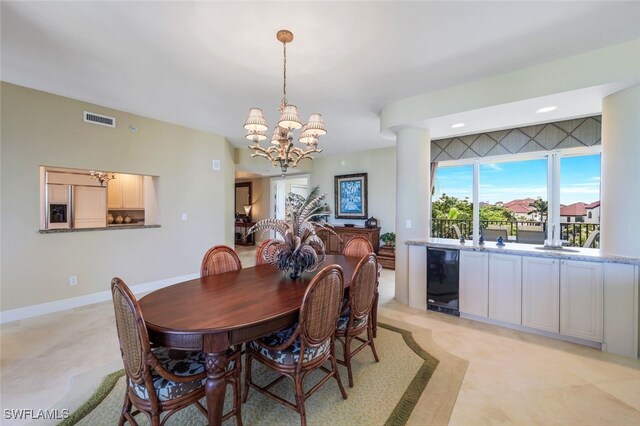 dining area featuring wine cooler and a notable chandelier