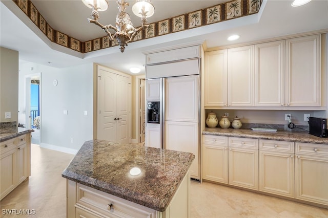 kitchen featuring a center island, dark stone countertops, and a tray ceiling