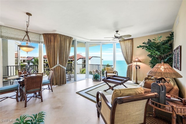 living room featuring ceiling fan, expansive windows, and a water view