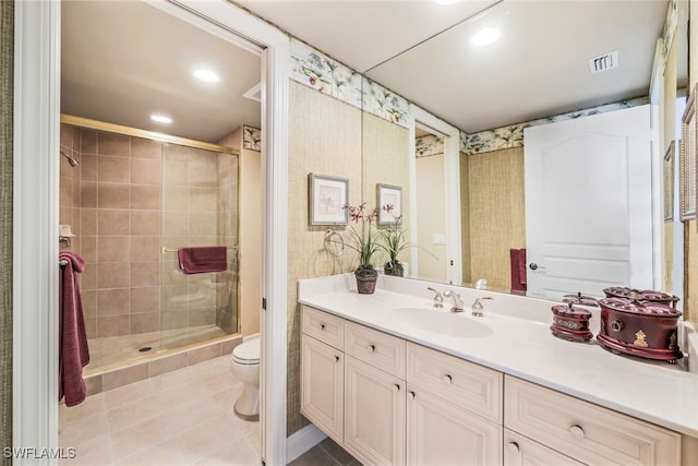 bathroom featuring tile patterned flooring, vanity, toilet, and an enclosed shower