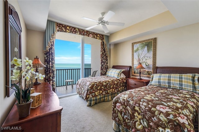 carpeted bedroom with access to exterior, a water view, and ceiling fan